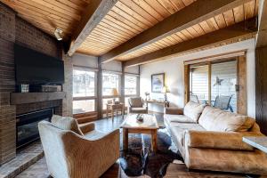 Lodge at Steamboat D101 في ستيمبوت سبرينغز: غرفة معيشة مع أريكة ومدفأة