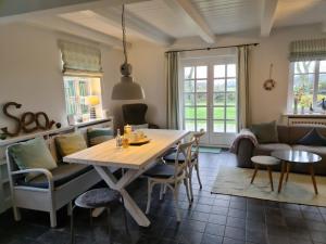 a kitchen and living room with a wooden table and chairs at Heimathafen - a09672 in Wrixum