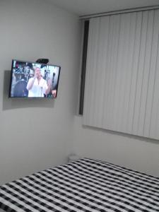 a bedroom with a tv on the wall and a bed at Habitación Privada in Ibagué
