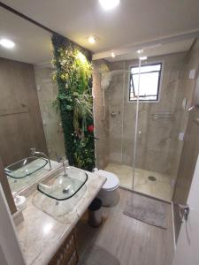 ein Badezimmer mit Dusche, Waschbecken und Toilette in der Unterkunft O Canto do Forte - Praia Grande in Praia Grande