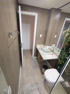 ein Badezimmer mit Toilette und Waschbecken in der Unterkunft O Canto do Forte - Praia Grande in Praia Grande + 17 Fotos