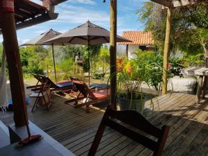 a wooden deck with chairs and an umbrella at Morere Jungle Lodge in Moreré