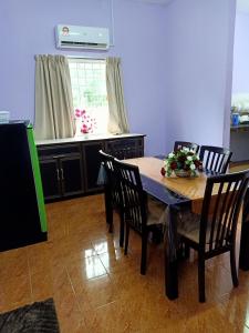 cocina con mesa de comedor y sillas en Aliza Scawa Homestay, en Kuala Pilah