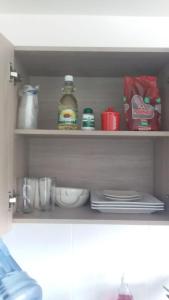 a kitchen shelf with dishes and a bottle of alcohol at Apartaestudio Sector Hayuelos in Bogotá