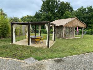 a gazebo with a table and chairs in the grass at Le Piquet Résidence-Pavillon in Cazaubon