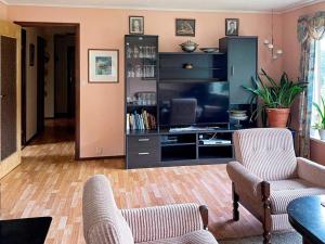 sala de estar con 2 sillas y TV en Apartment Reksteren, en Haukafer