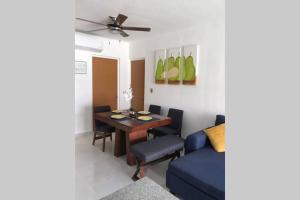 a living room with a table and a blue couch at Hermoso departamento con alberca in Manzanillo