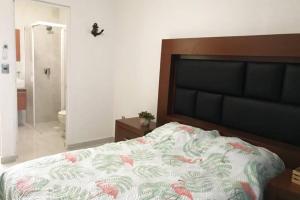 a bedroom with a large bed with pink flowers on it at Hermoso departamento con alberca in Manzanillo