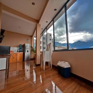 a kitchen with a table and chairs and large windows at Millennium Apartment in San Pedro La Laguna
