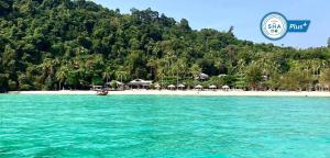 a view of a beach with a resort in the background at Thanya Beach Resort - SHA Plus in Ko Ngai