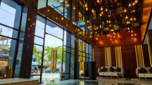 a lobby of a building with chairs and lights at Hotel Rasamala in Geutieue