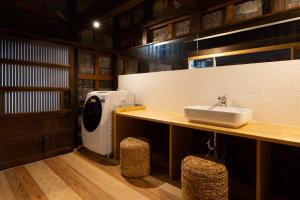 a bathroom with a sink and a washing machine at 龍助２５ in Komatsu