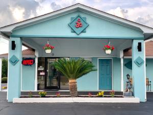 a blue building with flowers in front of it at Budget Inn - Laurens in Laurens