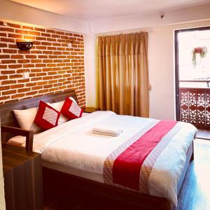 a bedroom with a bed with a brick wall at Hotel vintage Home in Bhaktapur