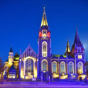 a large building with a clock tower at night at Austrian Apartments Leopolli near railway station in Lviv