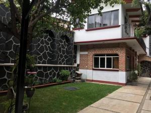 ein Haus mit einer Steinmauer und einem Hof in der Unterkunft Villa familiar El Ciruelo in Cuernavaca