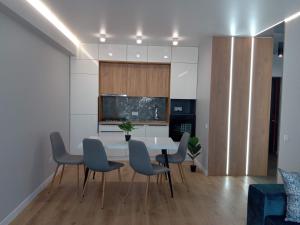 une salle à manger avec une table et des chaises blanches dans l'établissement Avalon Aparts Two bedrooms, à Lviv