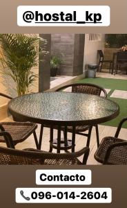 une table en verre avec des chaises autour de la terrasse dans l'établissement Hotel KP, à Portoviejo