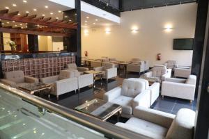 a waiting room with white chairs and tables at Al Shaiki Hotel in Al Jubail