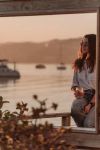 a woman sitting on a bench with a glass of wine at The Lofts Boutique Hotel in Knysna