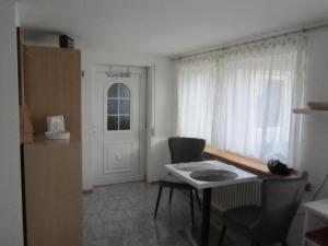 uma cozinha com mesa e cadeiras e uma janela em Apartment für zwei em Neukirchen vorm Wald