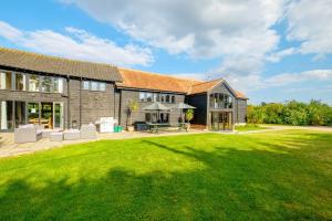 ein Haus mit großem Rasen davor in der Unterkunft Old Hall Barn - Aldeburgh Coastal Cottages in Darsham