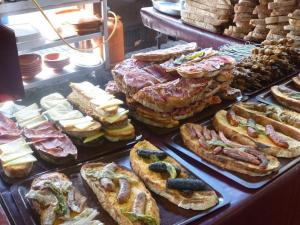 a display case with many different types of sandwiches and bread at Posada de los Cónsules in Consuegra