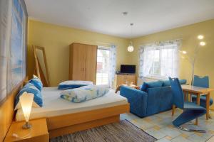 a bedroom with a bed and a blue couch at Seerano in Zingst