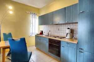 ツィングストにあるSeeranoのキッチン(青いキャビネット、テーブル、椅子付)