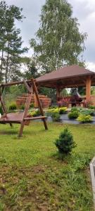 a bench and a gazebo in a park at Leśna Chata Kaszuby in Sulęczyno