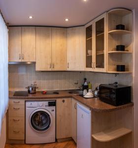 a kitchen with a washing machine and a microwave at Apartament Amber, Liepāja in Liepāja