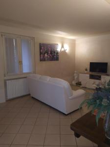 een woonkamer met een witte bank en een tv bij nido di dafne in Provaglio d'Iseo