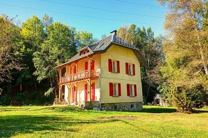 ein großes Haus mit roten Fenstern auf einem grünen Feld in der Unterkunft Le Balcon du grand bec in Planay