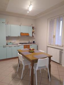 een keuken met een houten tafel en witte stoelen bij nido di dafne in Provaglio d'Iseo