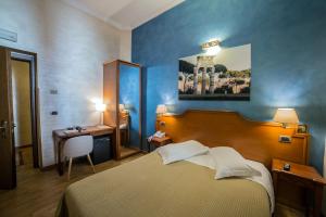 a bedroom with a bed and a table and a desk at Hotel Kent in Rome