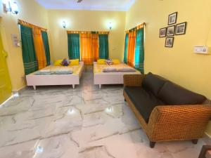 Nayantara في بولبور: غرفة معيشة بها سريرين وأريكة