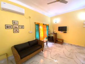 Nayantara في بولبور: غرفة معيشة بها أريكة وتلفزيون