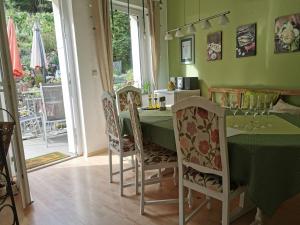 a dining room with a green table and chairs at Bed and Breakfast - Doppelzimmer in Sauerthal