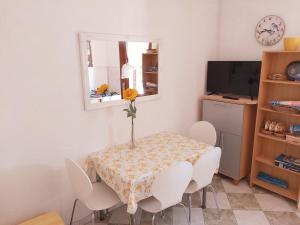 a dining room with a table and chairs and a television at Apartments Gabriel in Nin