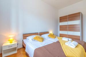 a bedroom with two beds and a table with a lamp at Apartment Terlevic in Sveti Lovreč Pazenatički