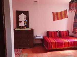 a bedroom with two beds and a dresser and a mirror at Casa La Palma in Chefchaouen