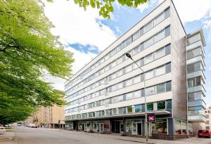 um edifício branco alto numa rua da cidade em 2ndhomes Tampere "Iso Ronka" Apartment - 2BR, Balcony & Great Location em Tampere