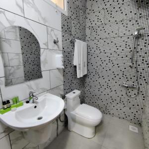 La salle de bains est pourvue de toilettes blanches et d'un lavabo. dans l'établissement MY HOTEL Nizwa Residence Hotel Apartement نزوى ريزيدنس, à Nizwa