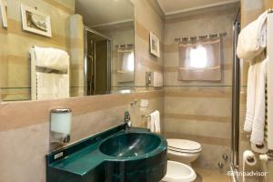 a bathroom with a green sink and a toilet at Hotel Kent in Rome