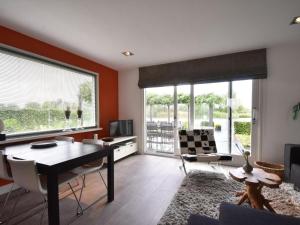 een woonkamer met een tafel en stoelen en een groot raam bij Riverside holiday home near Amsterdam in Nigtevecht
