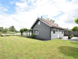 una pequeña casa negra con un patio en Riverside holiday home near Amsterdam en Nigtevecht