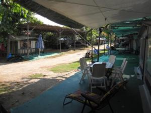 a patio with chairs and a table and an umbrella at Camping Tsitreli in Kalamitsi