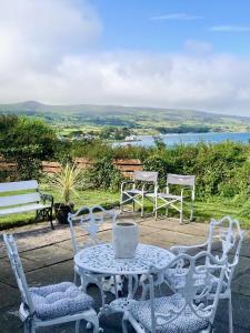 a table and four chairs and a table and a table and chairs at Ballygally Seaview and Garden Hideaway in Ballygalley