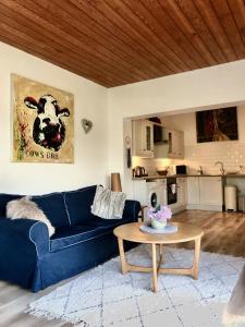 a living room with a blue couch and a table at Ballygally Seaview and Garden Hideaway in Ballygalley