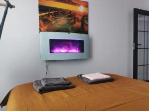 a room with a bed with two towels and a tv on the wall at Apartament przy Bursztynowym Stadionie in Gdańsk